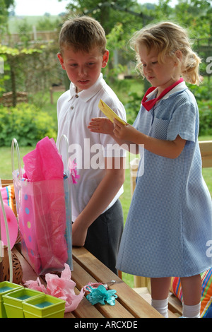 Mädchen und jungen öffnen vorhanden Fair haired Geburtstagskinder Stockfoto