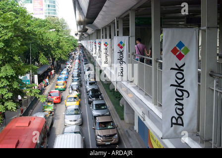 Verkehr reiht sich unterhalb der Bangkok Skytrain Bangkok Thailand viele Bewohner damit begonnen haben, Condomiums entlang den Himmel kaufen Stockfoto