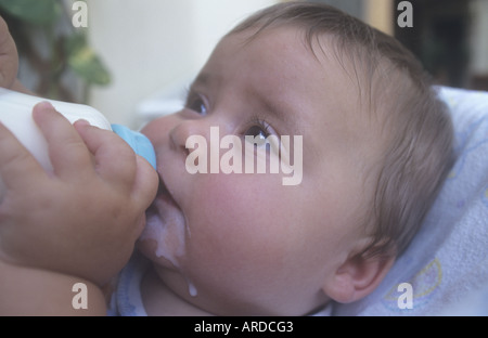 Babymädchen (7 Monate alt) trinken Milch aus der Flasche Stockfoto