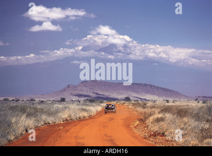 Straße im Tsavo West Nationalpark Kenia Ostafrika Kilimanjaro und Mawenzi kann gesehen werden, in den Himmel über der Straße Stockfoto