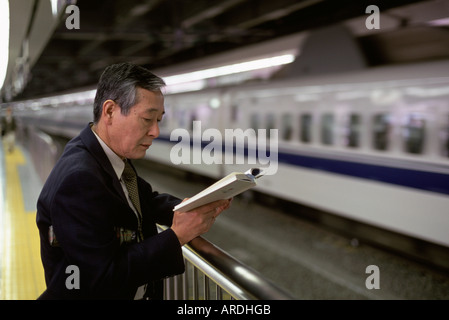 Ein Gehalt Mann oder Geschäftsmann wartet auf den Hochgeschwindigkeitszug oder Shinkansen nach Tokio Station in Tokio durchqueren Stockfoto