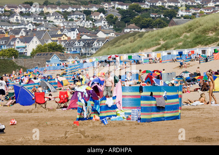 Urlauber mit Zelte Schirme und Windschutz an überfüllten Sandstrand im August Woolacombe Devon UK Stockfoto