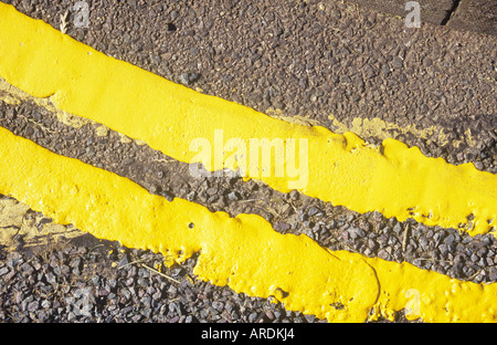 Detail von oben der frisch gestrichene doppelte gelbe Linien nach einer Kurve in der Straße Stockfoto