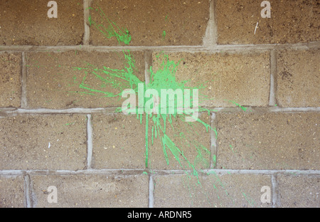 Nahaufnahme von einem Splat helle grüne Farbe auf eine Brise Blockwand geworfen Stockfoto