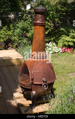 Garten Chiminea bedeckt in Designer Rost auf Holzterrasse Stockfoto