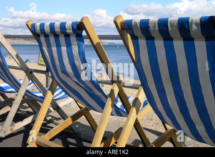 blaue und weiße Liegestühle auf einer Strandpromenade Stockfoto