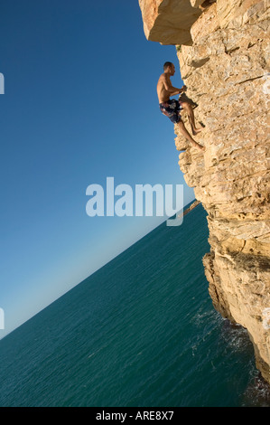 Lokalen Teenager auf einem großen Felsen klettern um einen guten Platz, Tauchen Sie ein in die unberührte Mittelmeer, nahe Cap Bon, Tunesien Stockfoto