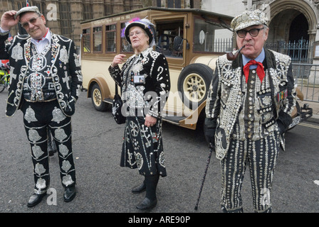 Zwei Pearly Kings und Pearly Queen auf einer Straße mit einem Vintage 'Fahrzeug' Coach dahinter - London Neujahrsparade 2008 Stockfoto