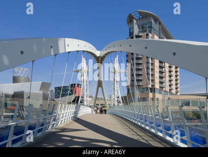 England, Manchester, Salford Quays, Millennium Bridge, moderne britische Architektur mit dem Lowry Centre in der Ferne Stockfoto