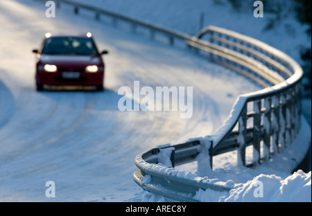 Metallische verschneite Straße Brücke Geländer und Auto fahren auf der Straße im Winter, Finnland Stockfoto