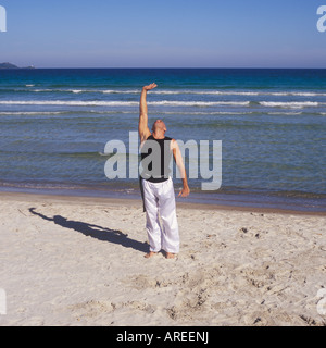 Professional-Tai-Chi und Kong Fu Lehrer Unternehmen Training am Strand in Mallorca, Balearen, Spanien. Stockfoto