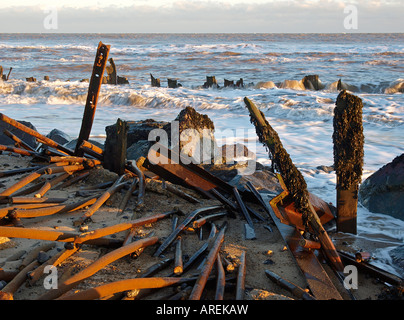 Ebbe auf happisburgh Strand mit gebrochenen Meer Abwehr und alte Gerüst Pole happisburgh Norfolk England England Stockfoto