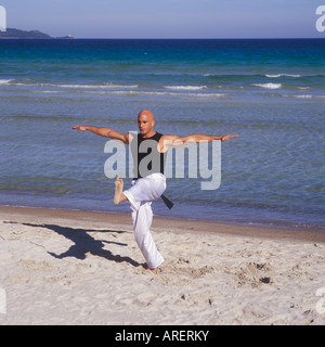 Professional-Tai-Chi und Kong Fu Lehrer Unternehmen Training am Strand in Mallorca, Balearen, Spanien. Stockfoto