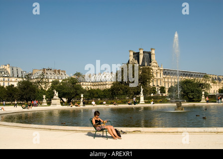 Frau im Stuhl neben einem Teich in der Jardin des Tuileries, Paris, Frankreich Stockfoto