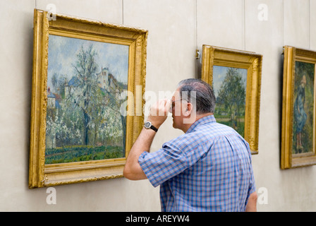 Besucher, die eng mit Blick auf ein Gemälde im Musée d ' Orsay, Paris, Frankreich Stockfoto