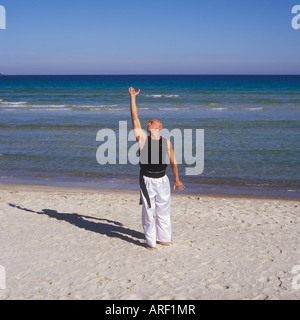 Professional-Tai-Chi und Kong Fu Lehrer Unternehmen Training am Strand in Mallorca, Balearen, Spanien. Stockfoto