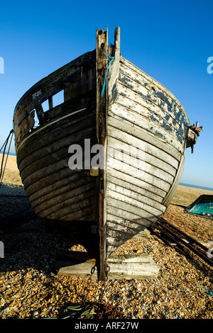 Altes verwittertes Fischerboot an einem Kieselstrand in Dungeness, Kent an einem blauen Himmelstag im Sommer Stockfoto