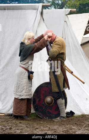 Viking-Frau bereitet ihren Mann für die Schlacht bei einem Wikinger-Reenactment-festival Stockfoto