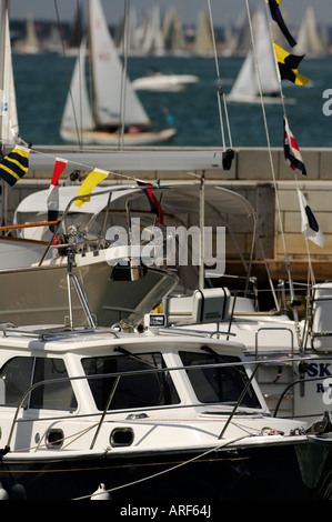 Motorboote und Kreuzer mit Segelbooten und Yachten im Hafen Yachthäfen in Cowes Week auf der Isle Of wight Stockfoto