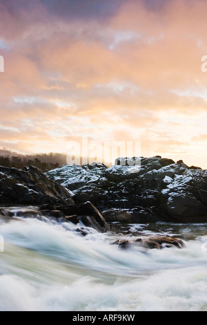 Eine bunte orange Sunrise entlang einige Stromschnellen des Potomac River in Great Falls National Park, Virginia. Stockfoto