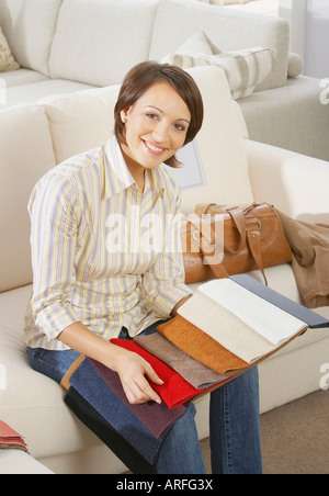 Frau sitzt auf dem Sofa im Möbelhaus Stockfoto