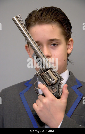 Porträt des jungen Modells veröffentlicht in Schuluniform mit Krawatte hält eine 44 Magnum Pistole Modell veröffentlicht Stockfoto