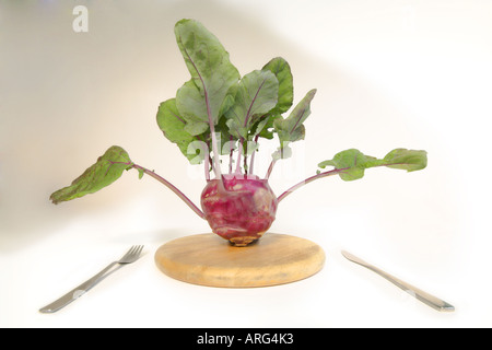 Kohlrabi, präsentiert auf einem hölzernen Teller mit Messer und Gabel Stockfoto