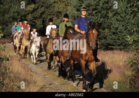 Gruppe von Mädchen und ihre Pferde Reiten in der Heide Stockfoto