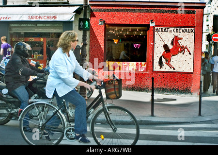 PARIS Marien, Frankreich, Straßenszene mit Pferdemutter-Shop Vintage Französisch Werbemosaik an der Wand Frau auf Fahrrad, alter französischer Schaufenster Vintage Stockfoto