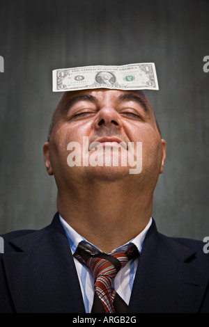 Geschäftsmann mit Dollar-Schein auf Kopf Stockfoto