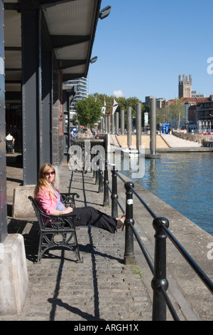 Frau mit Sonnenbrille ruht ihre Füße beim Blick über den Hafen in Bristol an der Wasserscheide Stockfoto