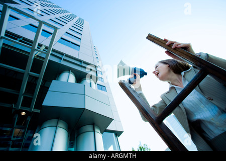 Geschäftsfrau auf Leiter mit Megaphon stehend Stockfoto