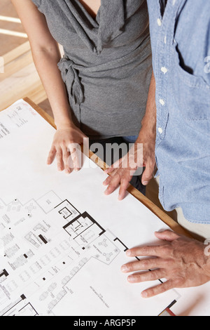 Mann und Frau betrachten Blueprint Stockfoto