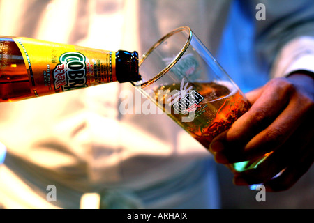 Kellner gießt Cobra Bier im indischen Restaurant in London 2007 Stockfoto