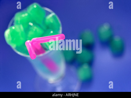 Drinking glass filled with green ice cubes Stockfoto
