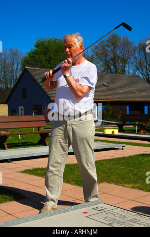 Nach dem Streik älterer Mann auf ein Mini-Golfplatz Golf spielen Stockfoto