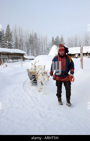 Mann trägt traditionellen Kleidung führt Rentiere in Lappland Nordfinnland Polarkreis Stockfoto