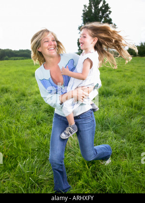 Mutter und Tochter spielen in einem Feld Stockfoto