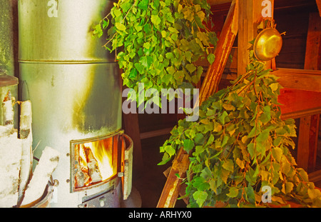 alten Saunaofen mit Feuer zwei Büschel Zweige der Birke in einer Sauna in Finnland Stockfoto