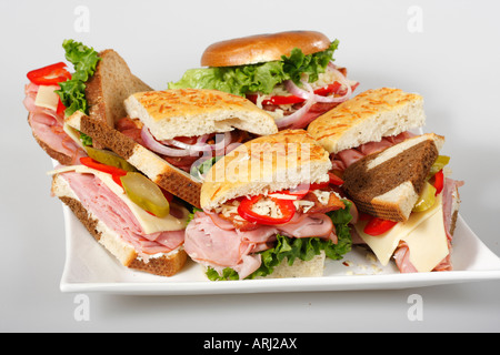 Platte mit Sandwiches auf weißem Hintergrund mit Gemüse Focaccia Brot Bagel halbiert auf Teller Tisch von oben isolierter Ausschnitt Hi-res Stockfoto