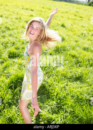 Junge Frau in einem grünen Feld tanzen Stockfoto