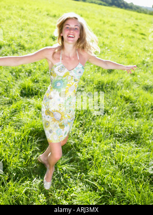 Junge Frau in einem grünen Feld tanzen Stockfoto