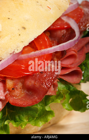 Focaccia-Brot-Sandwich mit gebratenem Schinken und Gemüsegarnitur auf dem Tisch von vorne oben in der Nähe vertikal in den USA Hi-res Stockfoto