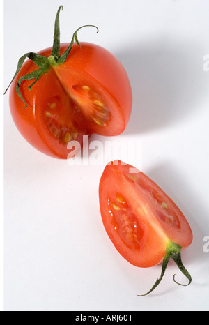 Eine rote Bio-Tomate mit seinen Stengel auf mit Segment schneiden Sie vor einem weißen Hintergrund Stockfoto