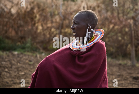 Eine Massai-Frau in traditioneller Kleidung und dekorativen Schmuck posiert in späten Nachmittag Licht außerhalb ihres Dorfes im Norden Tanzani Stockfoto