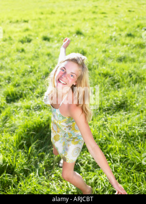 Junge Frau in einem grünen Feld tanzen Stockfoto