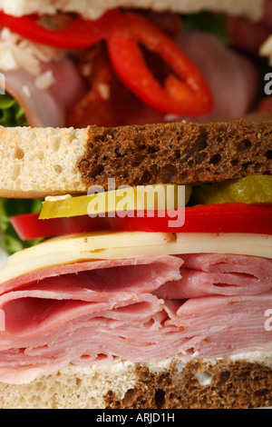 Querschnitt von Sandwichbrot mit Schinken- und Käsegemüse-Beilage auf dem Esstisch Nahaufnahme niemand vertikal in den USA Hi-res Stockfoto