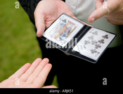 Ein Zauberer, ein Kartentrick mit einem weiblichen Gast auf einer Hochzeit durchführen Stockfoto