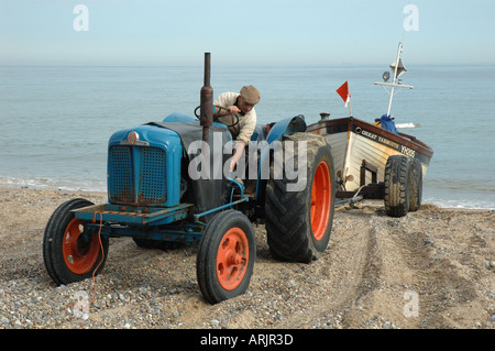 UK, Norfolk, Cromer, ein Fischer auf Traktor Boot Strand schleppen Stockfoto