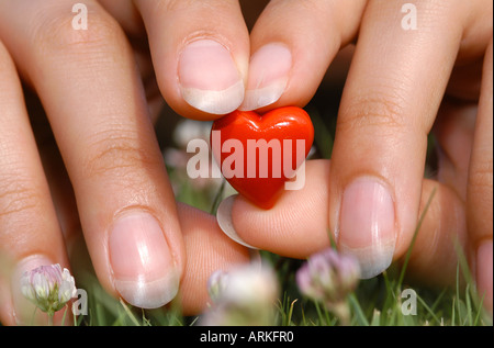 Symbolische Foto: Frauenhand mit einem Zwerg Herzen. Liebe. Stockfoto